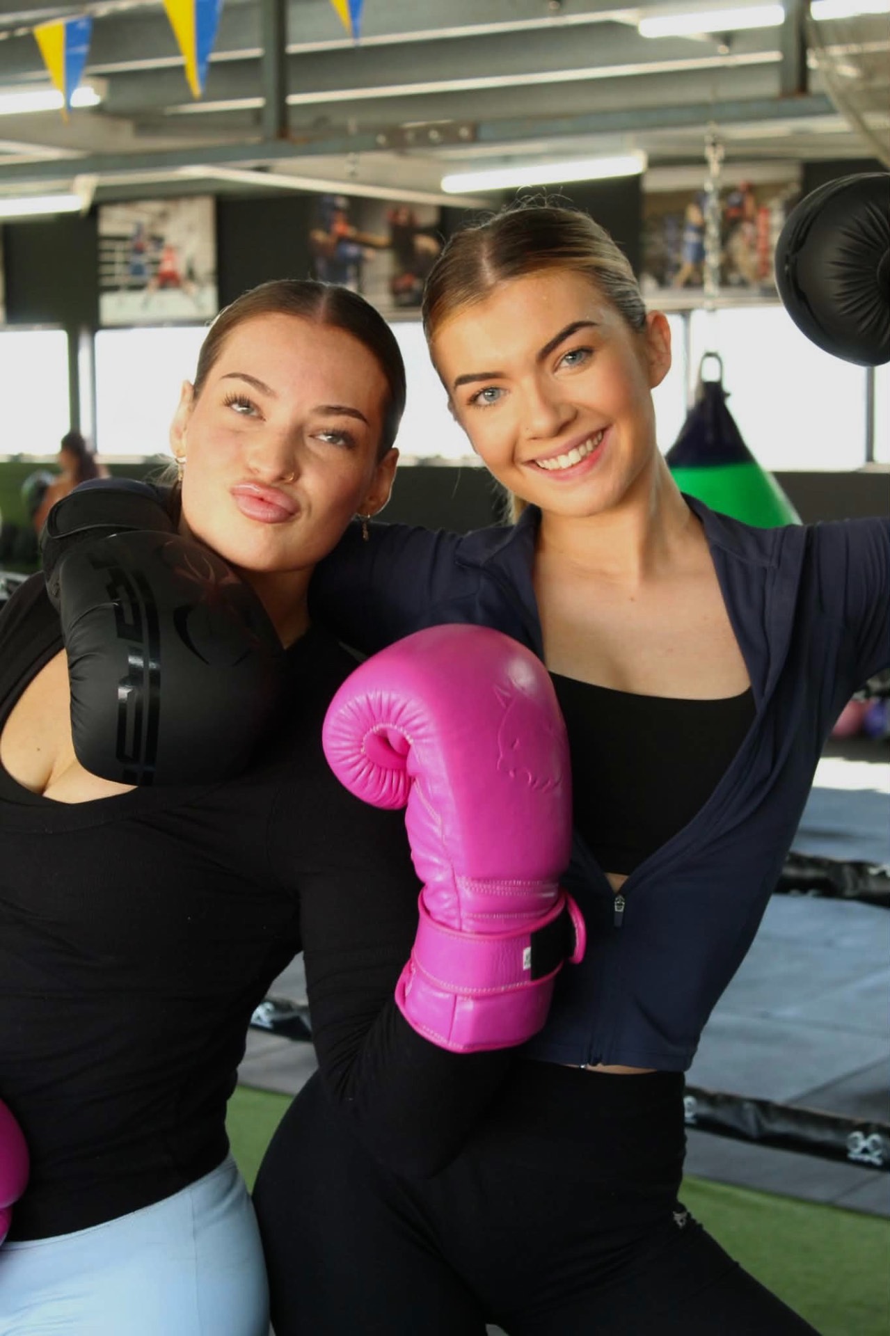 Two members smiling with gloves up