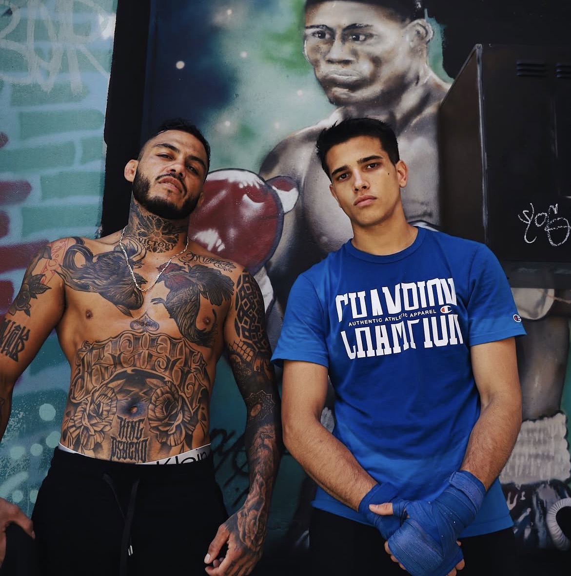 Marco Beltrán with Ruben in front of a boxing mural
