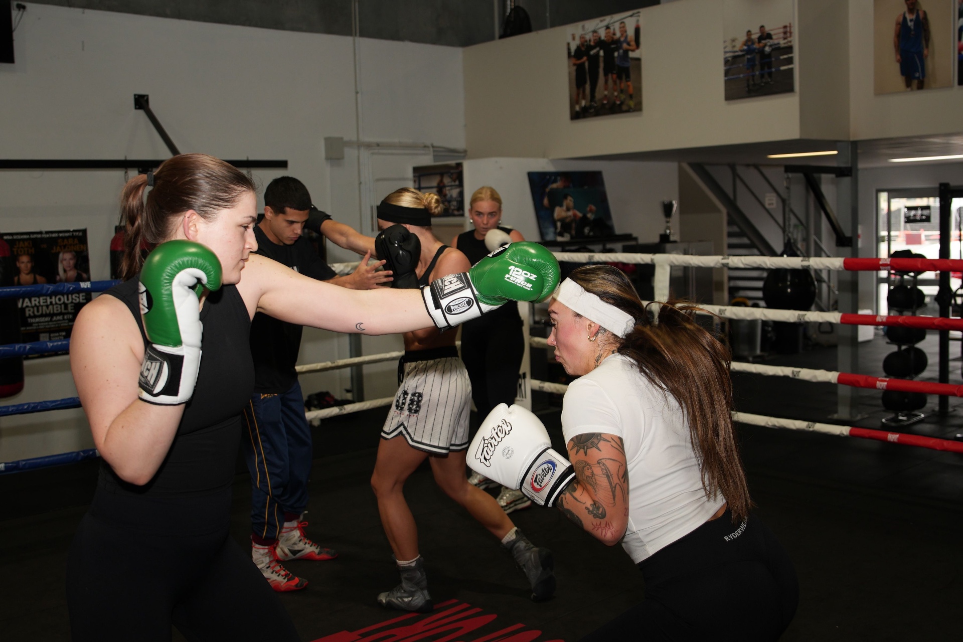 Women sparring with green gloves